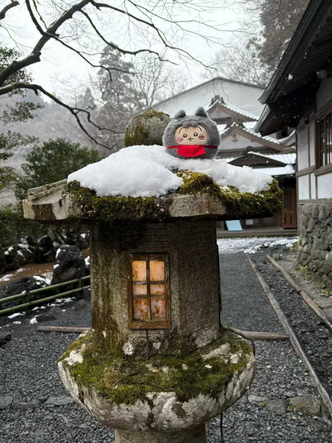 Usagi plush on a snow-capped stone lantern in Kyoto
